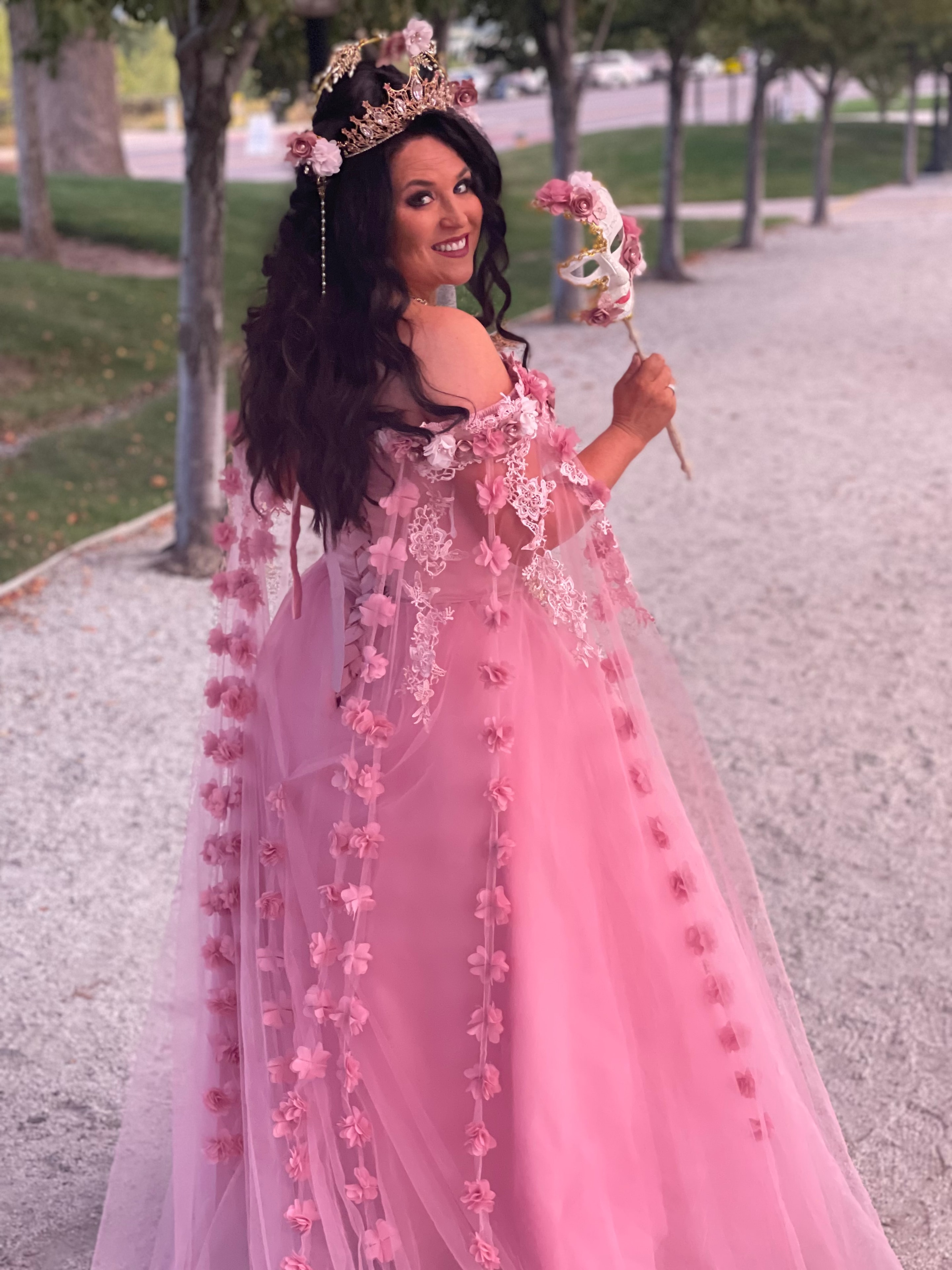Attendee in a stunning pink gown and floral crown at the Masquerade Ball