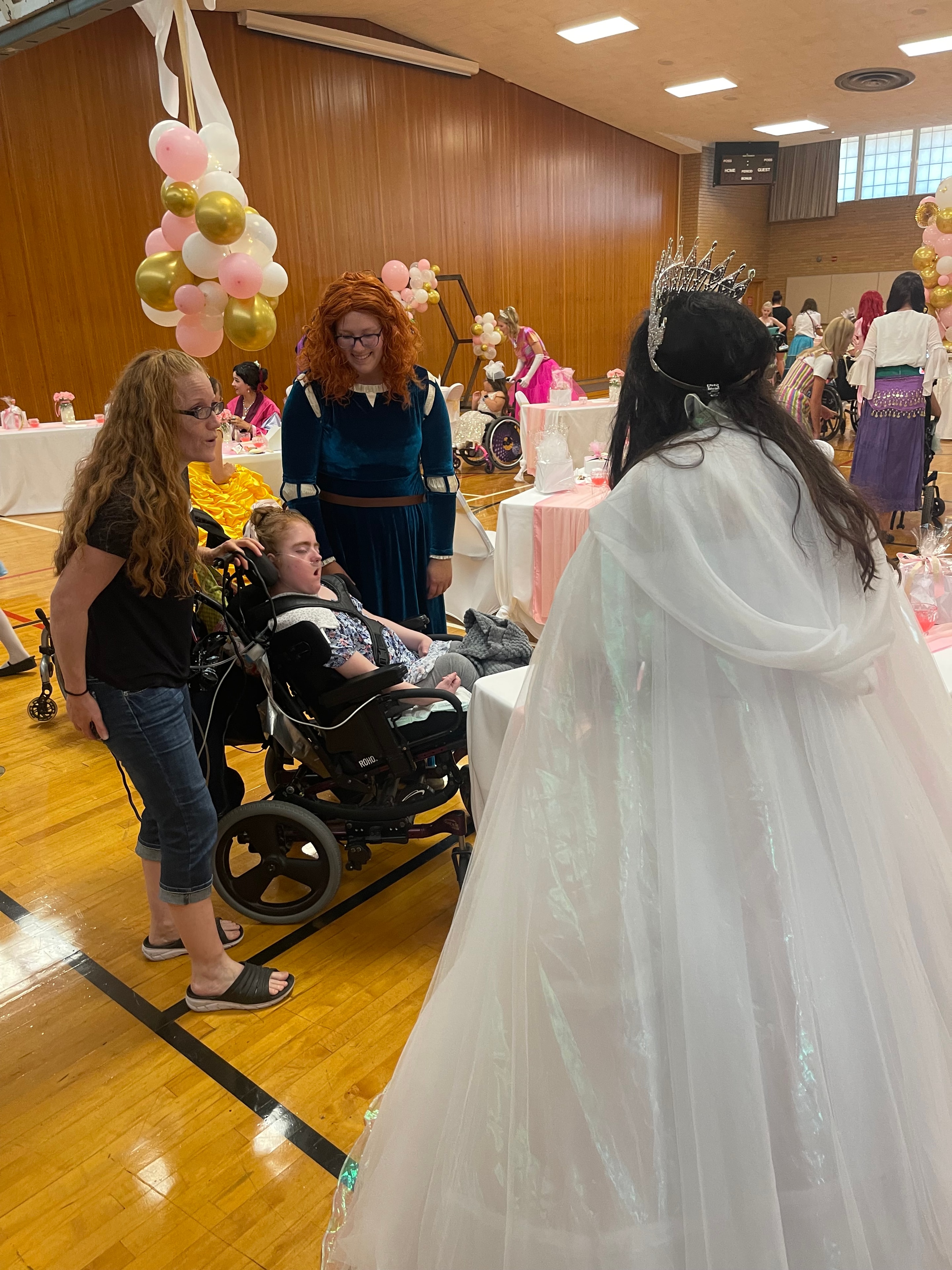 Crown Up Foundation volunteer with child at the Princess Pageant tea party